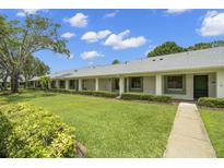 Charming condo exterior with well-manicured lawn and lush landscaping at 2557 Laurelwood Dr # 10D, Clearwater, FL 33763