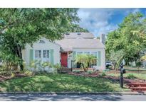 Charming single Gathering home with front yard, inviting red door, and shutters at 3516 W Santiago St, Tampa, FL 33629
