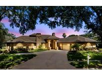 Stunning brick home features a large driveway, three-car garage, lush lawn, and a lovely arched entryway at 3772 Woodridge Pl, Palm Harbor, FL 34684