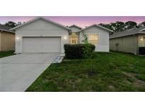 Charming single-story home featuring a two-car garage and well-maintained lawn at 518 Winthrop Dr, Spring Hill, FL 34609