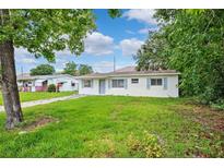 Charming one-story home featuring a well-manicured lawn and a quaint, inviting facade with blue shutters at 7891 67Th N St, Pinellas Park, FL 33781