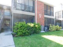 This is an exterior view of a 2-story condo with a patio and a green lawn at 9100 Dr Martin Luther King Jr N St # 303, St Petersburg, FL 33702