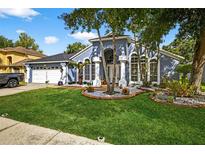 Charming home with a lush front yard, decorative landscaping and a two-car garage at 9220 Hidden Water Cir, Riverview, FL 33578