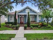 Charming home featuring a landscaped front yard and a welcoming porch with a red door at 10015 Brompton Dr, Tampa, FL 33626