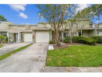 Charming townhouse with a well-manicured lawn, mature trees, and a private one-car garage at 1508 Adams E Cir, Largo, FL 33771