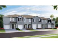 Charming townhomes featuring attached garages and beautifully landscaped front yards at 17465 Spanish Oak Loop, Land O Lakes, FL 34638