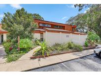 Charming two-story townhouse featuring well-kept landscaping, a walkway, and a private fence at 2078 Sunset Point Rd # 83, Clearwater, FL 33765