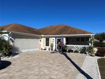 Charming home featuring a paver driveway, two car garage, and a welcoming front porch in a desirable community at 2457 E Del Webb Blvd, Sun City Center, FL 33573