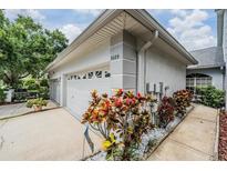 Charming home featuring a clean white garage door, beautiful landscaping, and a well-maintained exterior at 3029 Brookfield Ln, Clearwater, FL 33761