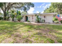 Charming single-story home featuring lush landscaping and an inviting front yard at 35836 Lakeshore Dr, Dade City, FL 33525
