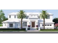 Stunning two-story white home featuring a symmetrical facade, brick accents, palm trees, and a manicured lawn at 38 Ladoga Ave, Tampa, FL 33606