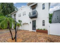 Charming two-story home showcasing a well-kept exterior, black awnings and brick driveway at 403 S Fremont Ave # 3, Tampa, FL 33606