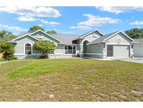 Charming single-story home with well-maintained lawn, mature landscaping, and attached two-car garage at 4399 Dior Rd, Spring Hill, FL 34609