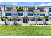 Beautiful townhome exterior with modern design, featuring a manicured lawn and palm trees at 4515 W North A St # 6, Tampa, FL 33609