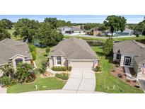 Charming home featuring a well-manicured lawn, mature trees, and a serene pond view at 5131 Gato Del Sol Cir, Wesley Chapel, FL 33544