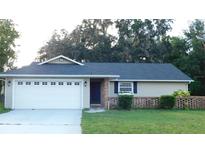 Charming single-story home with a well-maintained lawn, attached garage, and brick accents at 6605 Foxmoor Dr, Zephyrhills, FL 33542