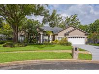 Beautiful single-story home with lush landscaping, two-car garage, and well-manicured lawn at 803 Brooker Village Cir, Lutz, FL 33548