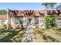 Charming townhome featuring a red tile roof, front yard, and walkway to the front door at 11511 113Th St # 22E, Largo, FL 33778