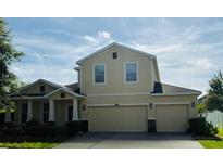 Charming two-story home with a two-car garage, manicured lawn, and classic architectural details at 12231 Fairlawn Dr, Riverview, FL 33579