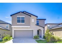 Two-story home featuring gray stucco, a gray garage door, and an arched entryway at 15505 Wicked Strong St, Sun City Center, FL 33573