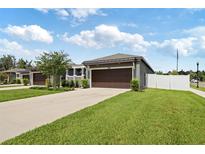 Charming single-story home featuring a spacious driveway and a two-car garage with an adjacent grassy lawn at 288 Villa Corte Dr, Lutz, FL 33549