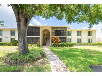 Inviting two-story condo building with lush landscaping, walkway, and screened-in lanais at 3114 Lake Pine Way # H2, Tarpon Springs, FL 34688