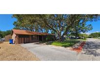 Charming single-story home with a well-maintained front yard, mature shade tree, and a long driveway at 3304 Alamar St, Lutz, FL 33558
