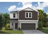 Charming two-story home boasts a two-car garage, neutral colors, and tasteful trim at 36964 Sagemoor Dr, Zephyrhills, FL 33541