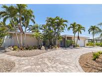 Single-story home with brick driveway and lush tropical landscaping at 417 41St Ave, St Pete Beach, FL 33706