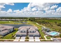 Stunning aerial view of a townhome community with golf course, pool, and serene lake views at 43250 Water Bird Way # 5921, Punta Gorda, FL 33982
