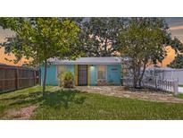 Charming turquoise home featuring a yellow door and manicured landscaping, creating a cheerful curb appeal at 5119 23Rd S Ave, Gulfport, FL 33707
