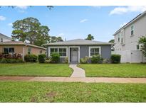 Charming single-story home with gray exterior, well-manicured lawn, and inviting walkway at 520 34Th N Ave, St Petersburg, FL 33704