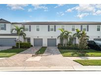 Inviting townhomes feature lush landscaping, brick driveways, and attached garages at 5519 Tripoli Dr, Palmetto, FL 34221
