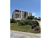 Well maintained exterior of condo building with lush landscaped entrance on a sunny day at 6218 Palma Del Mar # 303, St Petersburg, FL 33715