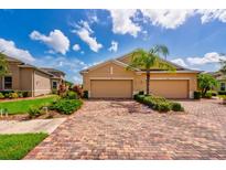 Charming home featuring a brick driveway, well-manicured landscaping, and a two-car garage at 644 Chipper Dr, Sun City Center, FL 33573