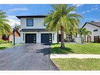 Charming two-story home with a lush front yard, modern garage doors, and a basketball hoop on the driveway at 729 89Th N Ave, St Petersburg, FL 33702