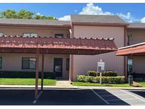 Inviting condo featuring covered parking and manicured landscaping around the building at 110 Lakeside Ct # 110, Oldsmar, FL 34677