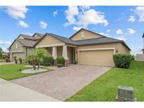 Charming single Gathering home with a two-car garage, beautiful landscaping, and a brick driveway at 11308 Chilly Water Ct, Riverview, FL 33569