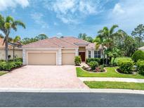 Charming home with a red tile roof, a paver driveway, and lush tropical landscaping at 11343 Dancing River Dr, Venice, FL 34292