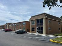 The exterior of a brown multi-Gathering building with covered parking and nice landscaping at 12760 Indian Rocks Rd # 904, Largo, FL 33774