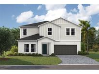 Inviting two-story home featuring a well-manicured lawn and a two-car garage at 36933 Sagemoor Dr, Zephyrhills, FL 33541