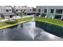 Aerial view of townhomes surrounding a pond with fountain, showcasing well-manicured lawns and community at 4148 Gauge Line Loop, Tampa, FL 33624