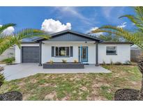 Charming single-story home boasts a freshly painted exterior, neat landscaping, and a modern garage door at 8045 Colton Dr, Port Richey, FL 34668
