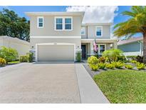 Charming two-story home featuring a neutral facade, a two-car garage, and well-manicured landscaping at 8050 Praise Dr, Tampa, FL 33625