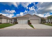 Well maintained single-story home with tile roof, two-car garage, driveway and manicured landscaping and lawn at 8354 Palmetto Ct, Englewood, FL 34224