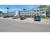 Three-story condo building with white facade, multiple balconies, and parking at 8396 111Th St # 301, Seminole, FL 33772