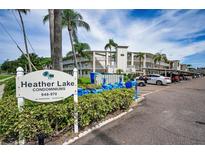 Heather Lake Condominiums exterior view with palm trees and visible parking at 960 Virginia St # 204, Dunedin, FL 34698