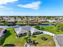 A stunning aerial view of a well-maintained home with lush landscaping and waterfront views at 2110 W View Dr, Sun City Center, FL 33573