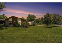 Charming single-story home with a well-manicured lawn and mature trees under a gorgeous twilight sky at 2270 Spruce Ln # B, Palm Harbor, FL 34684
