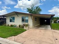Cozy single-story home featuring a covered carport and well-maintained front yard with inviting curb appeal at 34325 Country Breeze Ave, Wesley Chapel, FL 33543